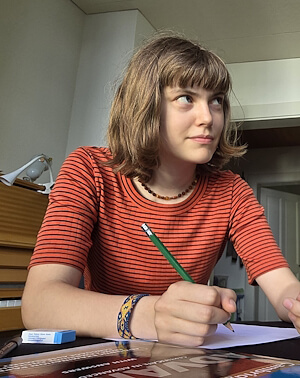 Gymnasiastin schreibt Erklärungen von Kurt Wieland während der Nachhilfe Gymnasium auf ein Blatt.