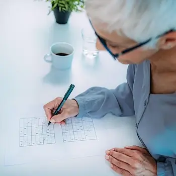 Privatunterricht Bern – Seniorin löst konzentriert ein Sudoku als geistiges Training.