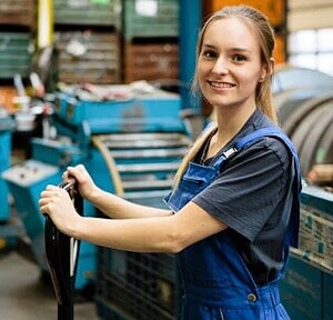 Berufsfachschülerin in der Ausbildung zur Metallbaukonstrukteurin EFZ steht in der Werkstatt an einem Ballettwagen; Bild für die Nachhilfe-Berufsfachschule.
