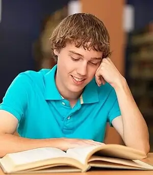 Schüler liest konzentriert einen Text während der Nachhilfe Sekundarschule.