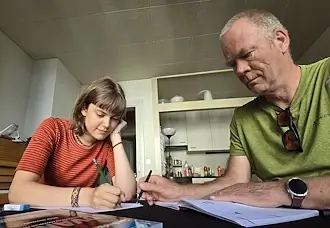 Kurt Wieland erklärt einer Gymnasiastin eine schriftliche Aufgabe im Deutschunterricht in Bern.