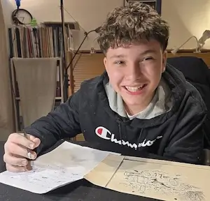 Lachender Schüler bei einer schriftlichen Übung im Privatunterricht in Bern